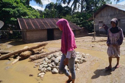 Warga melintas di endapan lumpur Warga melintas di endapan lumpur